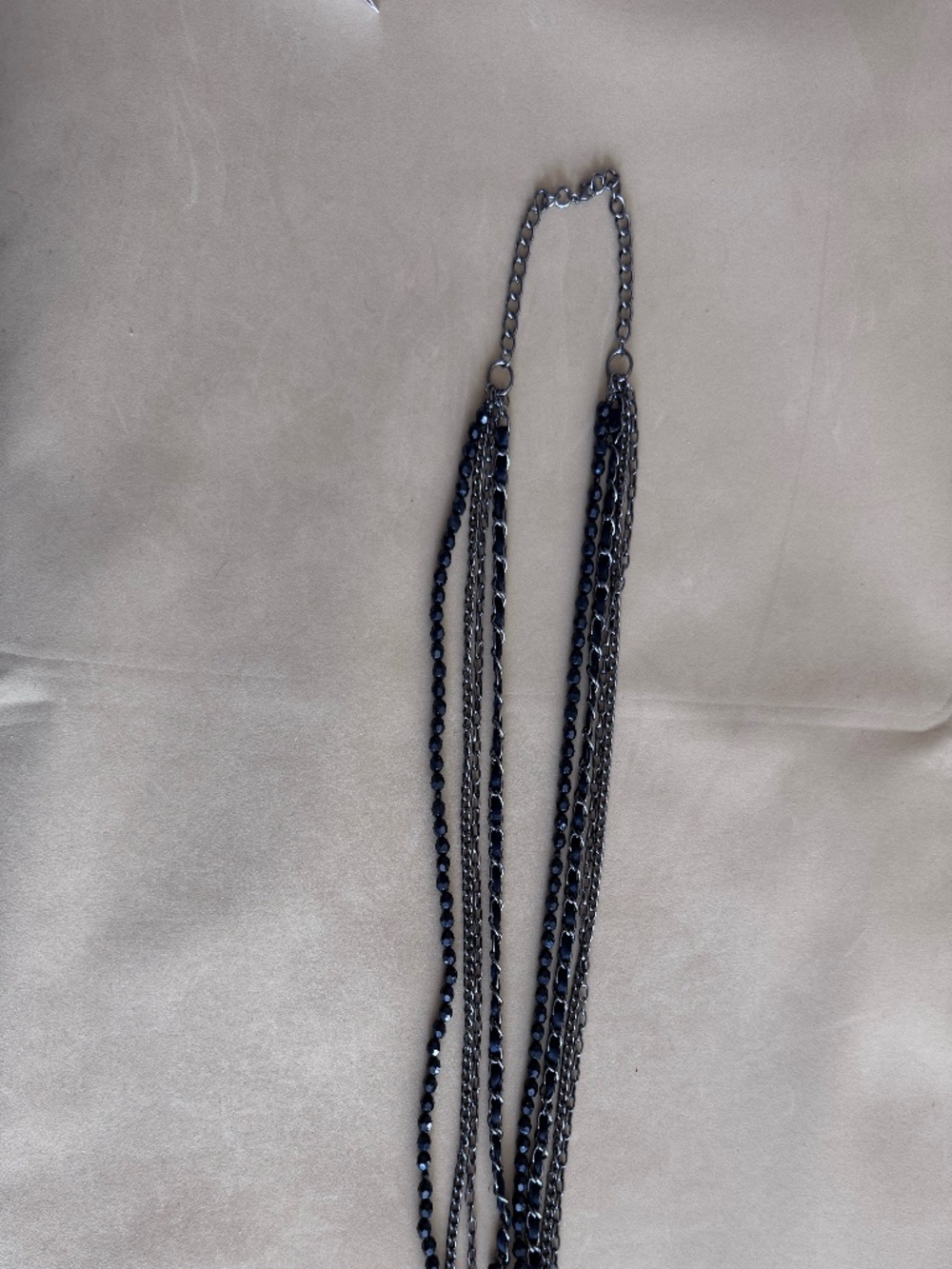 Multi-strand necklace with layered chains and black beads